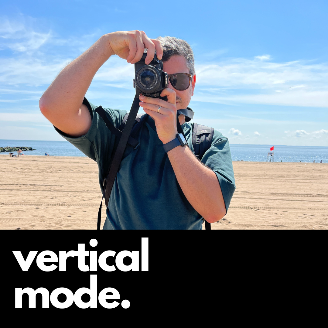 Camstrap Voyager hands-free camera strap worn across the torso, holding a DSLR close to the body.