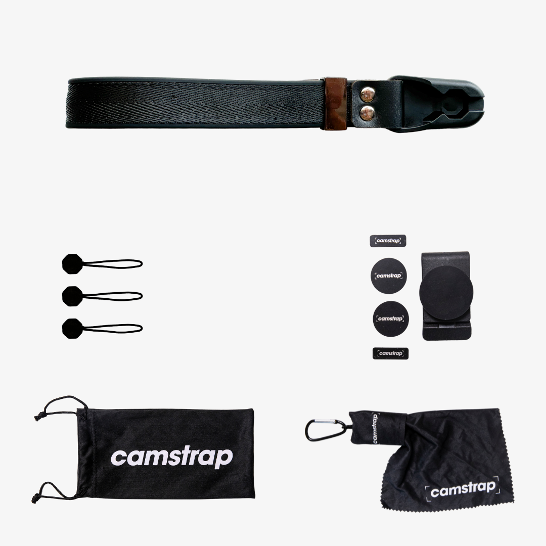 Camstrap SafeGrip wrist strap attached to a mirrorless camera, with a magnetic lens cap holder on the side.