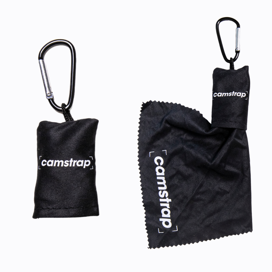 Camstrap Mikrofaser-Objektivreinigungstuch beim Reinigen der Frontlinse eines DSLR-Objektivs.