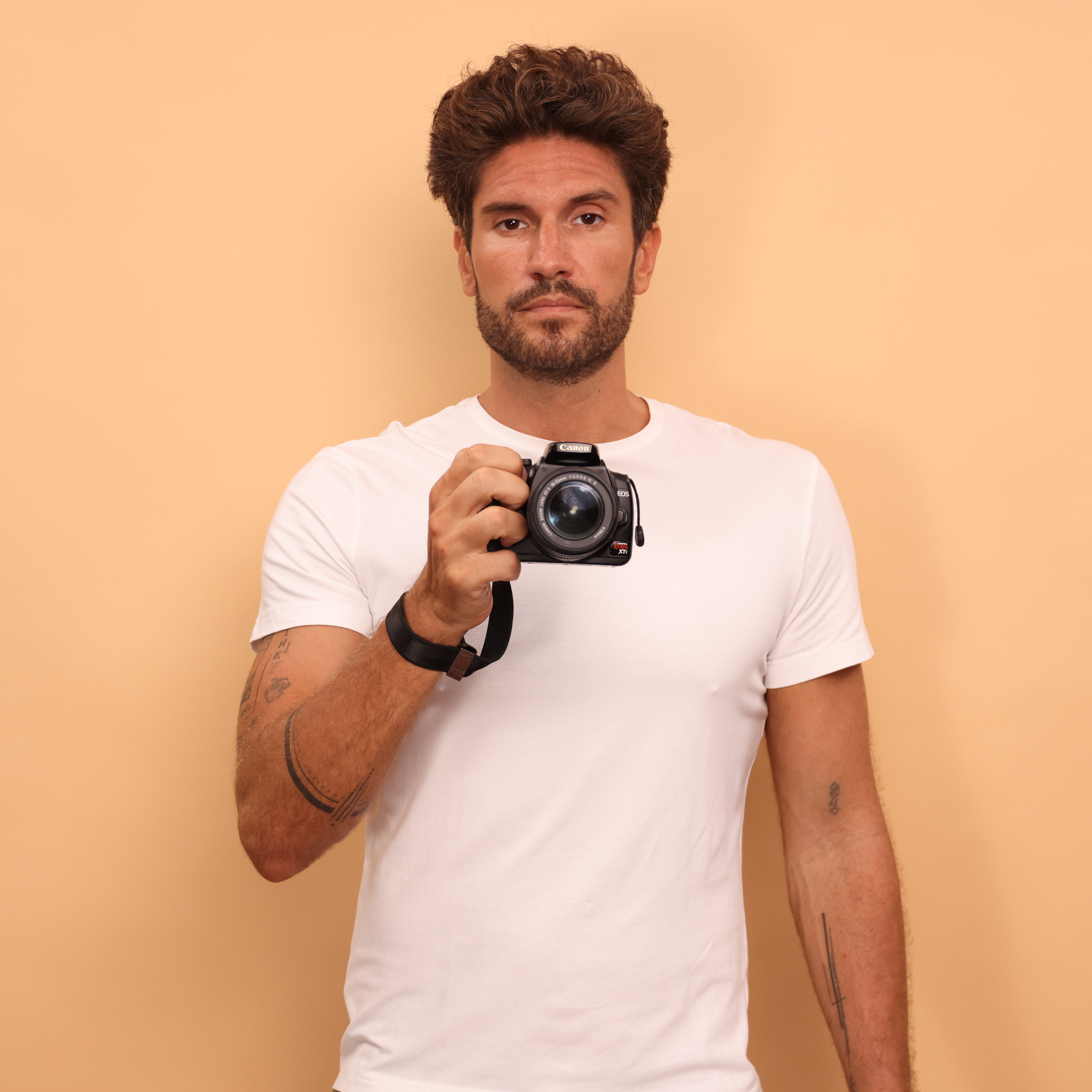 Camstrap SafeGrip wrist strap attached to a mirrorless camera, with a magnetic lens cap holder on the side.
