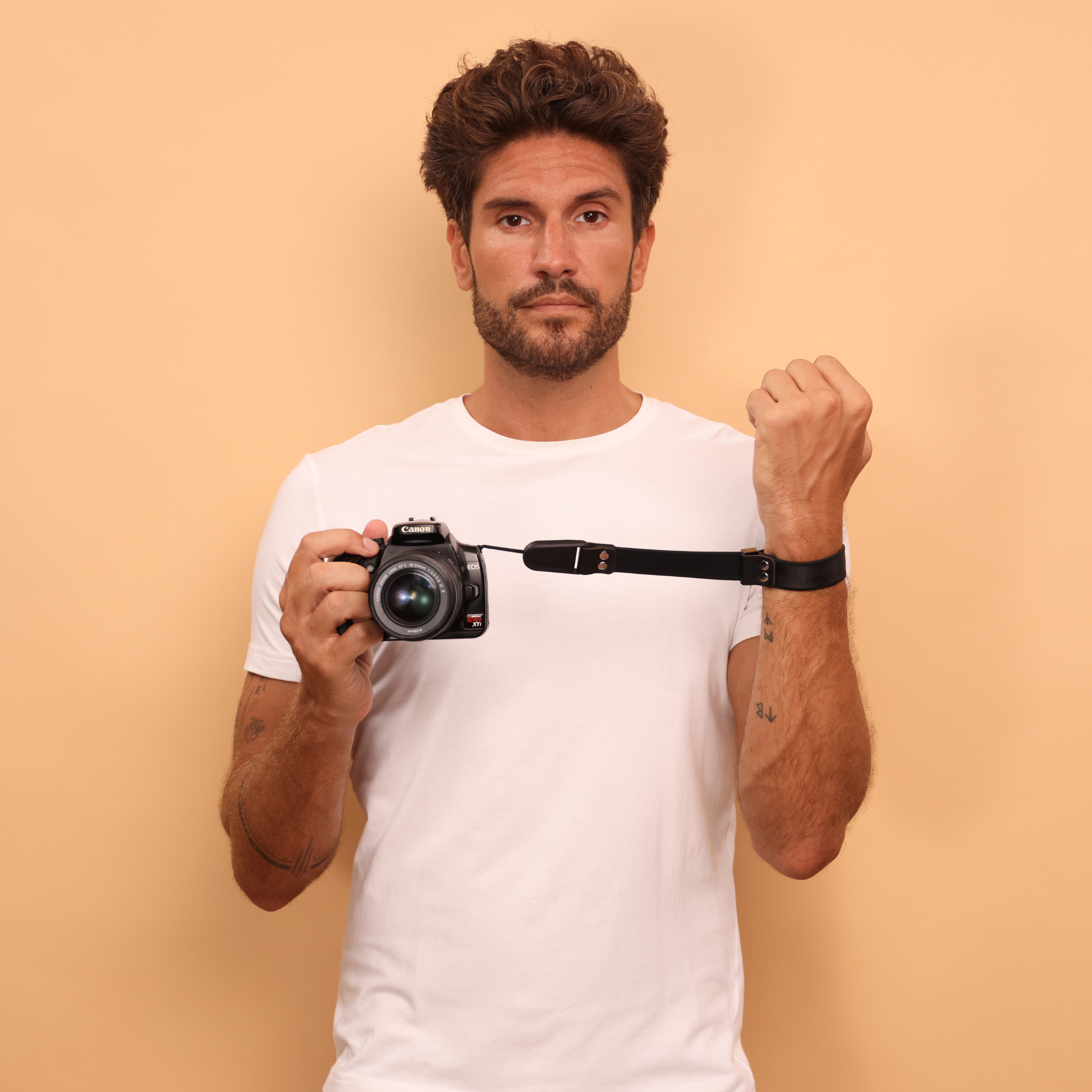 Camstrap SafeGrip wrist strap attached to a mirrorless camera, with a magnetic lens cap holder on the side.