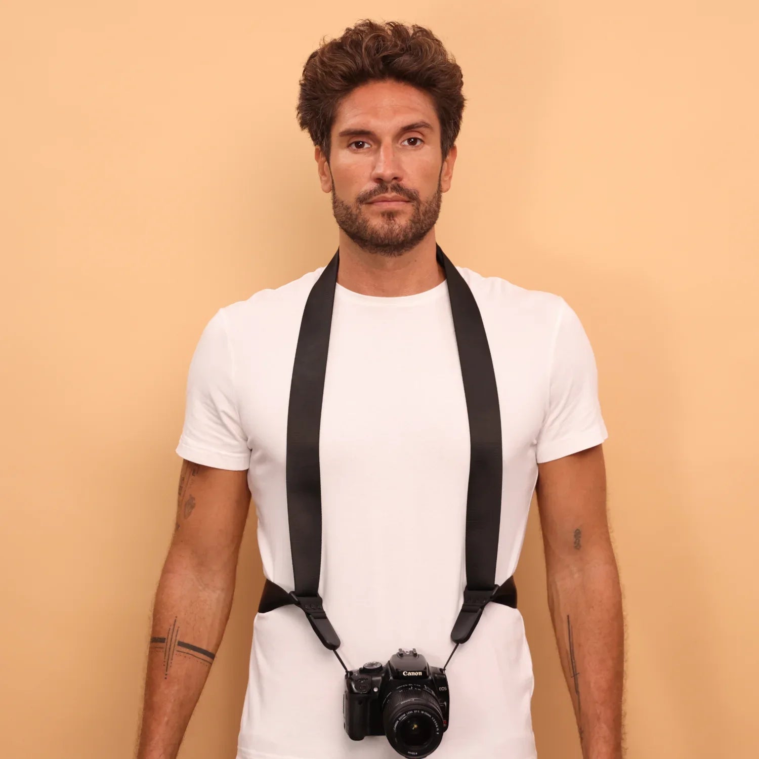 Camstrap Explorer hands-free camera harness worn over both shoulders, supporting a DSLR with a telephoto lens.