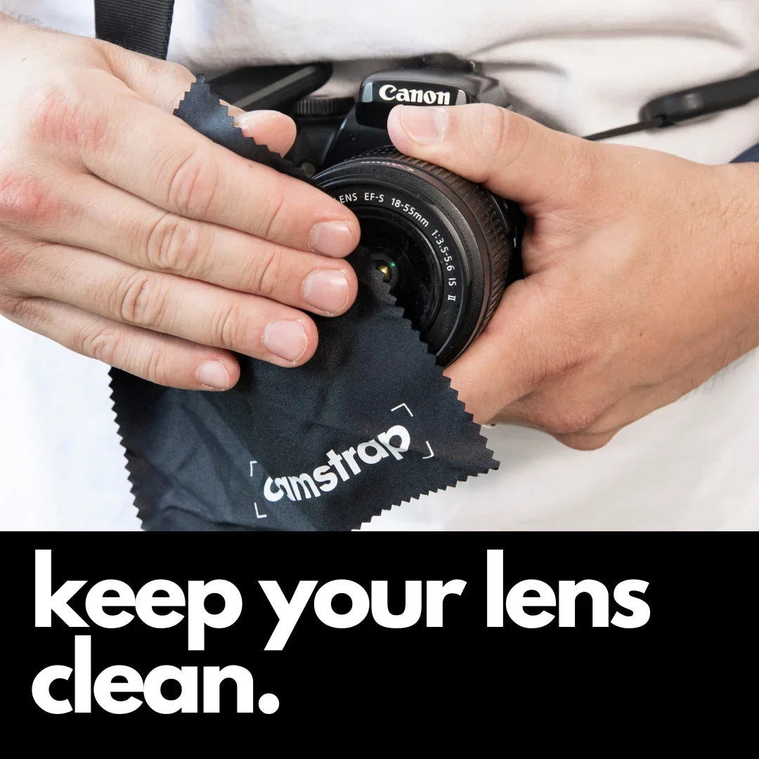 Camstrap microfiber lens cleaning cloth wiping the front element of a DSLR camera lens.