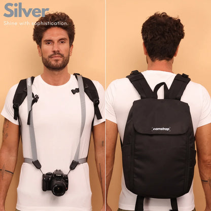 Camstrap Nomad 20L hands-free photography backpack worn on one shoulder with a DSLR clipped to the strap.