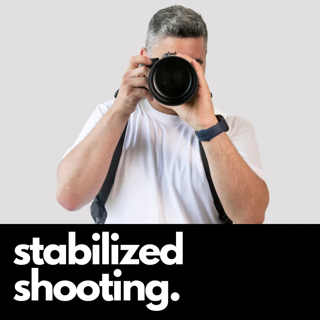 Camstrap Explorer hands-free camera harness worn over both shoulders, supporting a DSLR with a telephoto lens.