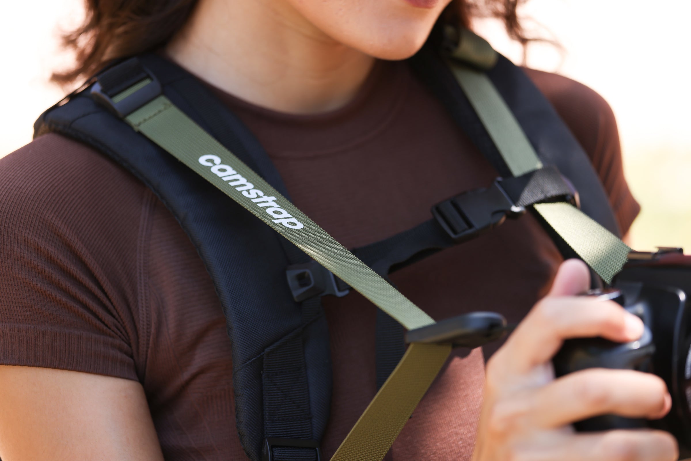 Sac à dos photo Camstrap Satellite ultraléger pliable, partiellement replié, à côté de sa pochette taille paume.