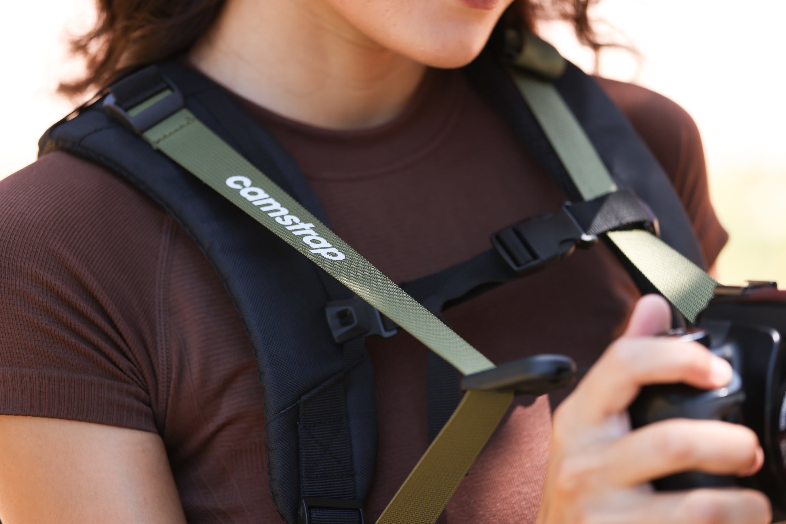 Camstrap Satellite超軽量折りたたみカメラバックパックを一部折りたたみ、手のひらサイズのポーチの隣に置いた様子