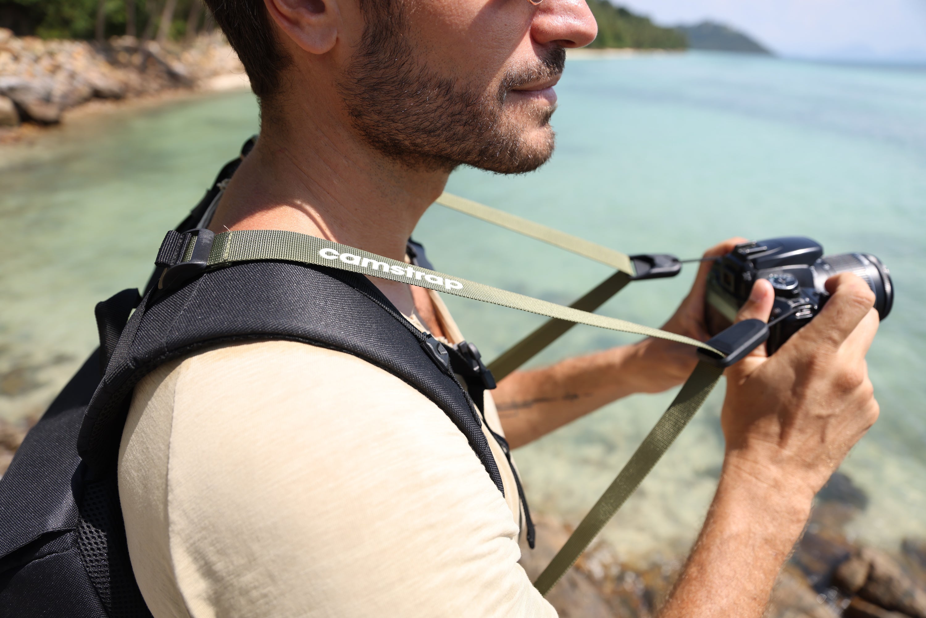 Camstrap Satellite超軽量折りたたみカメラバックパックを一部折りたたみ、手のひらサイズのポーチの隣に置いた様子