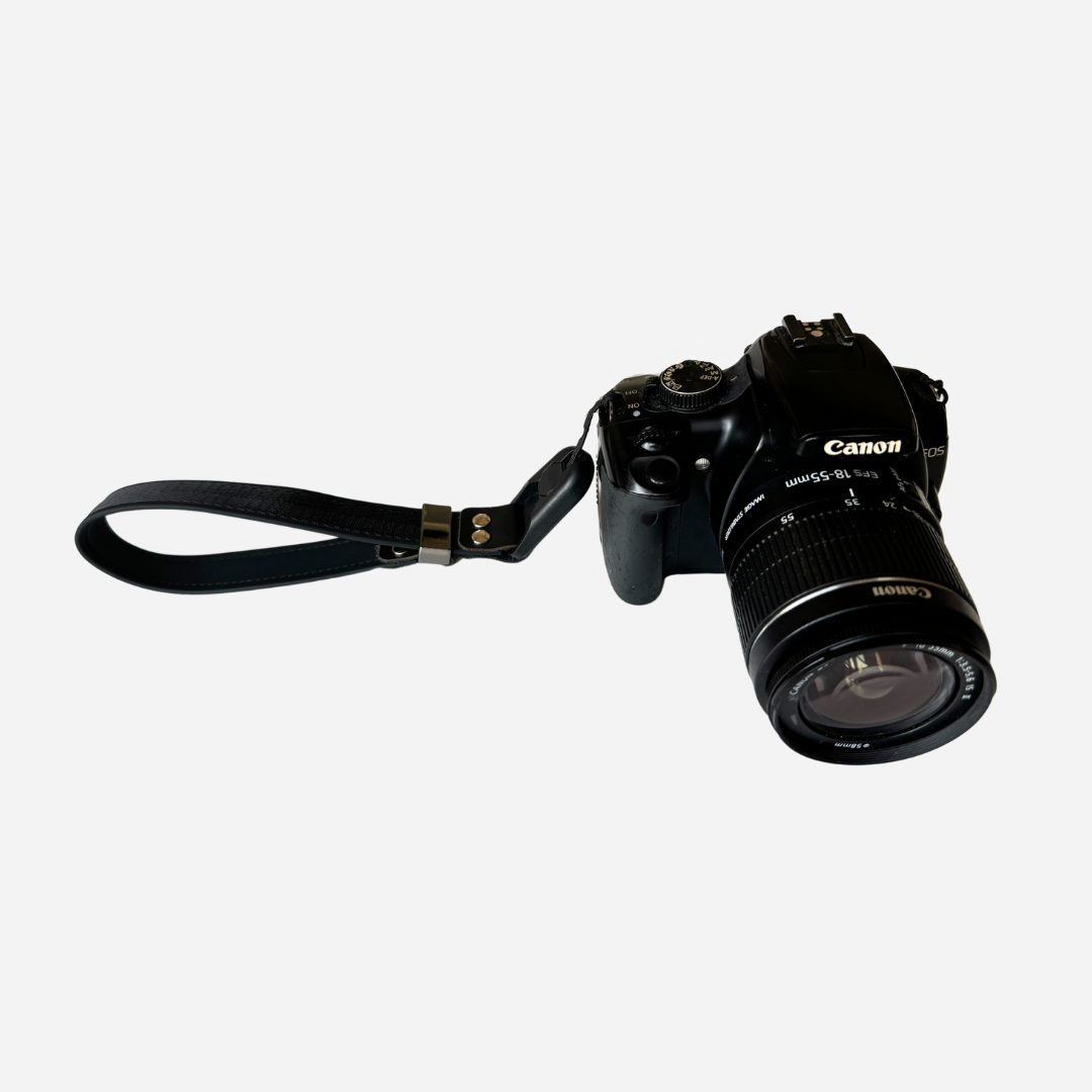 Cinturino da polso Camstrap SafeGrip su una mirrorless, con porta-tappo magnetico sul lato.
