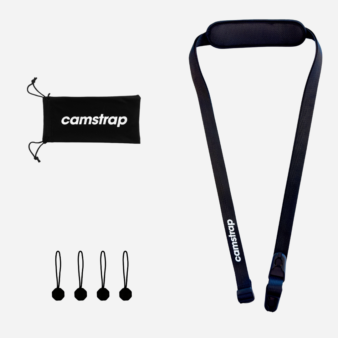 Camstrap Voyager Freihand-Kameragurt quer über dem Oberkörper getragen, hält eine DSLR eng am Körper.