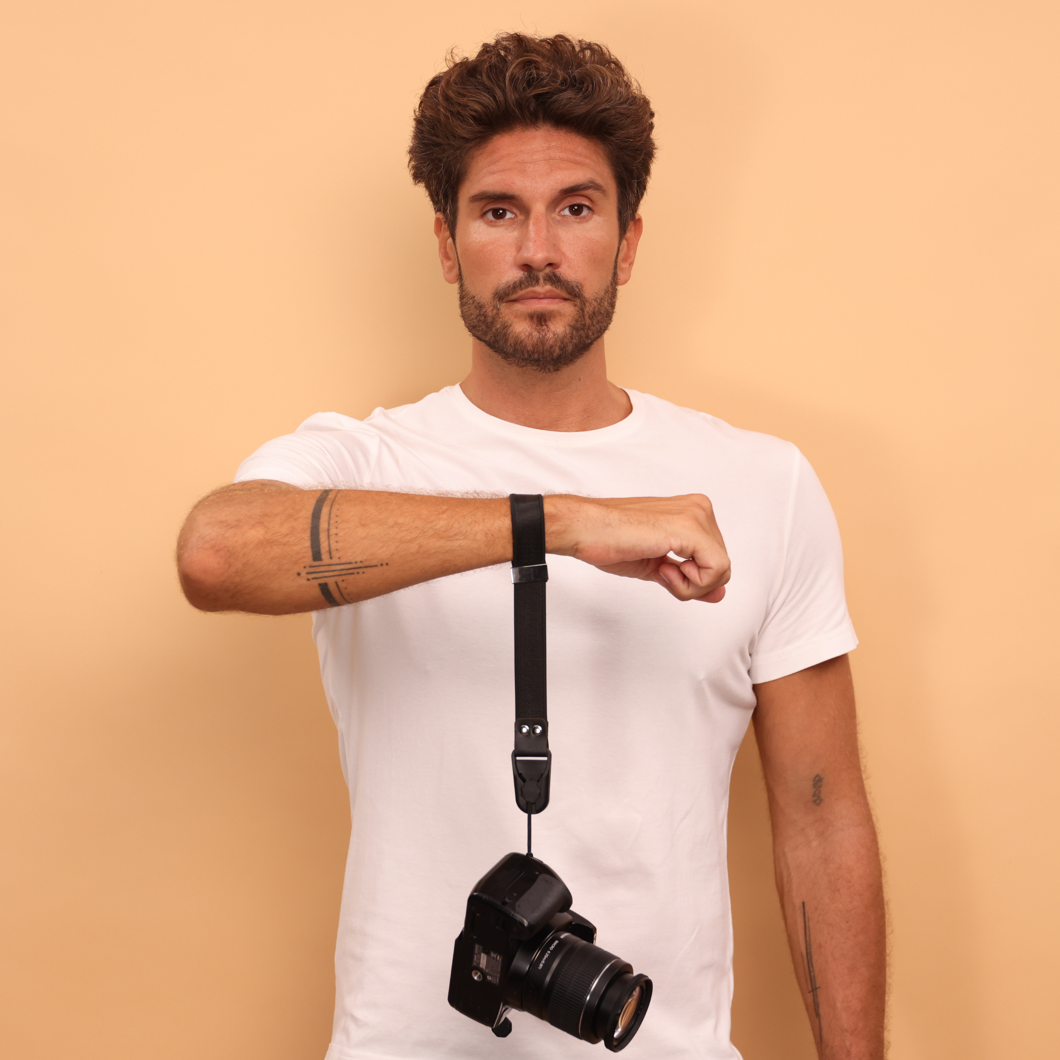 Cinturino da polso Camstrap SafeGrip su una mirrorless, con porta-tappo magnetico sul lato.