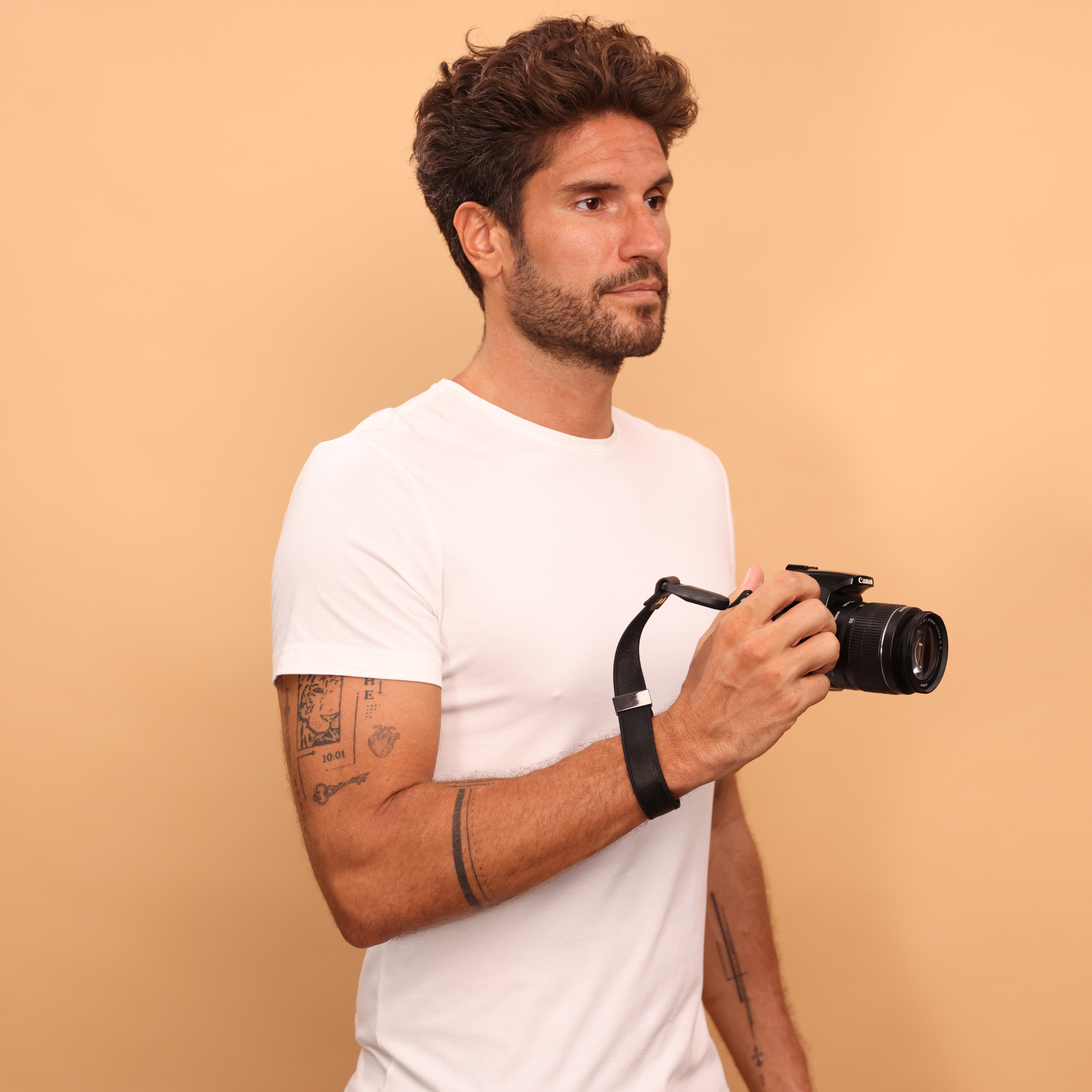 Cinturino da polso Camstrap SafeGrip su una mirrorless, con porta-tappo magnetico sul lato.